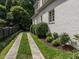 Charming white brick home with a well-maintained lawn and a paved driveway, surrounded by lush greenery at 2900 Glenanneve Pl, Raleigh, NC 27608