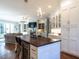 Open concept kitchen with seating island flowing into living area with fireplace and built-in bookcases at 2900 Glenanneve Pl, Raleigh, NC 27608