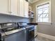 Well-equipped laundry room with stainless steel washer and dryer, cabinetry, and a window at 2900 Glenanneve Pl, Raleigh, NC 27608