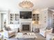 Bright living room featuring a fireplace, custom built-ins, and a decorative chandelier at 2900 Glenanneve Pl, Raleigh, NC 27608