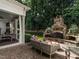 Outdoor patio featuring a stone fireplace, comfortable seating, and manicured landscaping for relaxed outdoor living at 2900 Glenanneve Pl, Raleigh, NC 27608