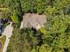 Aerial view of a beautiful brick home surrounded by lush trees on a large lot at 327 Davis Love Dr, Chapel Hill, NC 27517