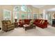 Bright living room features arched windows, plantation shutters, and comfortable red sectional sofa at 327 Davis Love Dr, Chapel Hill, NC 27517