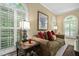 Bright sitting room with large windows, plantation shutters, and a cozy sofa at 327 Davis Love Dr, Chapel Hill, NC 27517