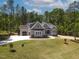 Aerial view of beautiful home, showcasing its manicured lawn, long driveway and the surrounding lush greenery at 3925 Cedar Knolls Dr, Youngsville, NC 27596