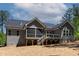 Backyard view showcasing deck and screened porch of a two-story gray home at 3925 Cedar Knolls Dr, Youngsville, NC 27596