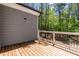 A wooden deck with white railings overlooks a lush, green backyard filled with trees at 3925 Cedar Knolls Dr, Youngsville, NC 27596