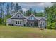Charming gray home with stone accents, manicured lawn, and lush landscaping provides beautiful curb appeal at 3925 Cedar Knolls Dr, Youngsville, NC 27596