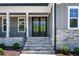 Close-up of a front entrance featuring stone steps, a black double door, and manicured landscaping at 3925 Cedar Knolls Dr, Youngsville, NC 27596