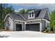 Spacious garage with multiple doors and modern gray siding, complemented by a concrete driveway at 3925 Cedar Knolls Dr, Youngsville, NC 27596