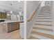 Open kitchen with a large island, marble countertops, and an adjacent staircase at 3925 Cedar Knolls Dr, Youngsville, NC 27596