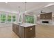 Open kitchen includes island with sink and view of the living room fireplace at 3925 Cedar Knolls Dr, Youngsville, NC 27596