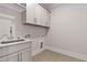 Well-lit laundry room with modern sink, cabinets, and hookups at 3925 Cedar Knolls Dr, Youngsville, NC 27596