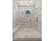 Modern tiled shower featuring dual shower heads, a bench, and decorative tiled flooring at 3925 Cedar Knolls Dr, Youngsville, NC 27596