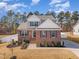 Attractive two-story home featuring brick accents, a landscaped yard, a paved walkway, and a well-kept lawn at 40 Ironwood Blvd, Youngsville, NC 27596