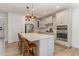 Bright kitchen boasts a large island, stainless steel appliances, white cabinetry, and modern pendant lighting at 40 Ironwood Blvd, Youngsville, NC 27596