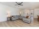 Bright living room featuring a large gray sectional sofa and modern, light wood-look flooring at 40 Ironwood Blvd, Youngsville, NC 27596