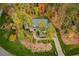 Aerial shot of a beautiful home surrounded by lush greenery and colorful trees at 4201 Henderson Pl, Pittsboro, NC 27312