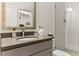 Bright bathroom featuring a modern sink, stone countertop, framed mirror and a tiled walk-in shower at 4201 Henderson Pl, Pittsboro, NC 27312