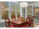 Bright dining area with a wood table, cushioned chairs, and large windows showcasing the wooded scenery at 4201 Henderson Pl, Pittsboro, NC 27312