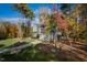 Scenic view of a gray two-story home with lush landscaping, mature trees and a long driveway at 4201 Henderson Pl, Pittsboro, NC 27312