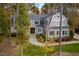 Inviting gray home with lush landscaping, mature trees, and a circular driveway, offering classic charm and curb appeal at 4201 Henderson Pl, Pittsboro, NC 27312