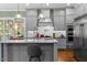 Open-concept kitchen with stainless steel appliances, center island, and modern fixtures at 4201 Henderson Pl, Pittsboro, NC 27312