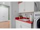 Practical laundry space with white cabinets, a sink, and modern washing machine at 4201 Henderson Pl, Pittsboro, NC 27312