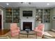 Charming living room featuring custom built-in shelves, a fireplace, and large windows at 4201 Henderson Pl, Pittsboro, NC 27312