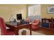 This office features a desk, computer, bookshelf and two red upholstered chairs at 4201 Henderson Pl, Pittsboro, NC 27312