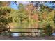 Scenic view of a tranquil pond surrounded by colorful fall foliage and a split rail fence at 4201 Henderson Pl, Pittsboro, NC 27312