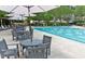Community pool surrounded by tables, chairs, and umbrellas for a comfortable outdoor experience at 4201 Henderson Pl, Pittsboro, NC 27312