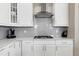 White kitchen with gray tile backsplash and stainless steel appliances at 501 Old Ride Drive, Holly Springs, NC 27540