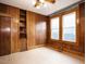 Bedroom with wood-paneled walls, a ceiling fan, and closet at 504 Washington St, Raleigh, NC 27605