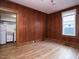 Living room with a kitchen view, a window, and wood-paneled walls at 504 Washington St, Raleigh, NC 27605