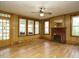 Living room with wood-paneled walls, hardwood floors, a fireplace, and lots of light at 504 Washington St, Raleigh, NC 27605