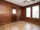 View of the living room with a window and wood paneling at 504 Washington St, Raleigh, NC 27605