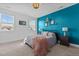 Main bedroom with teal accent wall and cozy bedding at 547 Vine Pkwy, Pittsboro, NC 27312