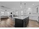 Open concept kitchen features an island and a view into the living room at 547 Vine Pkwy, Pittsboro, NC 27312