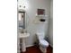 Powder room with pedestal sink, floating shelves, and toilet at 626 Churton Grove Blvd, Hillsborough, NC 27278