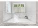 Relaxing soaking tub with marble surround and window at 805 Pinehurst Dr, Chapel Hill, NC 27517