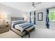 Spacious bedroom with a gray upholstered bed and blue striped bedding at 805 Pinehurst Dr, Chapel Hill, NC 27517