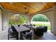 Elegant covered patio with dining and seating areas, overlooking a golf course at 805 Pinehurst Dr, Chapel Hill, NC 27517