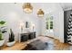 Bright entryway with hardwood floors, white brick walls, and unique light fixtures at 805 Pinehurst Dr, Chapel Hill, NC 27517