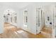 Long hallway with hardwood floors and views into bedroom and pool area at 805 Pinehurst Dr, Chapel Hill, NC 27517