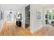 Long hallway with hardwood floors, wine room, and modern art at 805 Pinehurst Dr, Chapel Hill, NC 27517