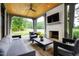 Covered patio with comfortable seating, a fireplace, and a large TV at 805 Pinehurst Dr, Chapel Hill, NC 27517