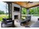 Covered patio with fireplace, seating area, and views of the pool and golf course at 805 Pinehurst Dr, Chapel Hill, NC 27517