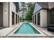 Long, rectangular pool in a backyard setting with stonework and lounge chairs at 805 Pinehurst Dr, Chapel Hill, NC 27517