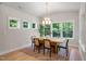 Dining room boasts large windows, modern light fixture, and wood table with seating at 125 Charlotte Knoll St # 15, Zebulon, NC 27597